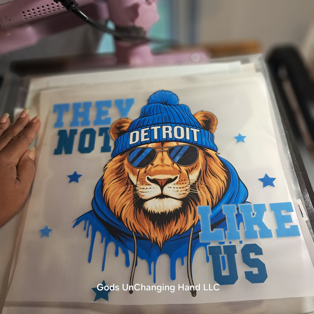 Close-up of They Not Like Us lion design with Detroit beanie and sunglasses